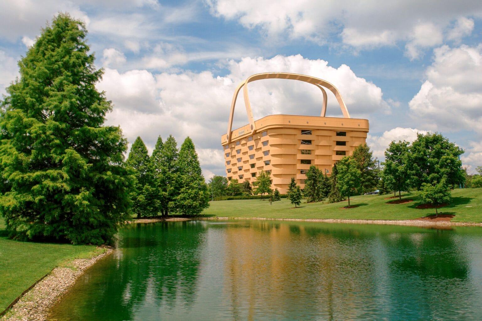a building foregrounded by a pond, shaped like a giant picnic basket a building foregrounded by a pond, shaped like a giant picnic basket