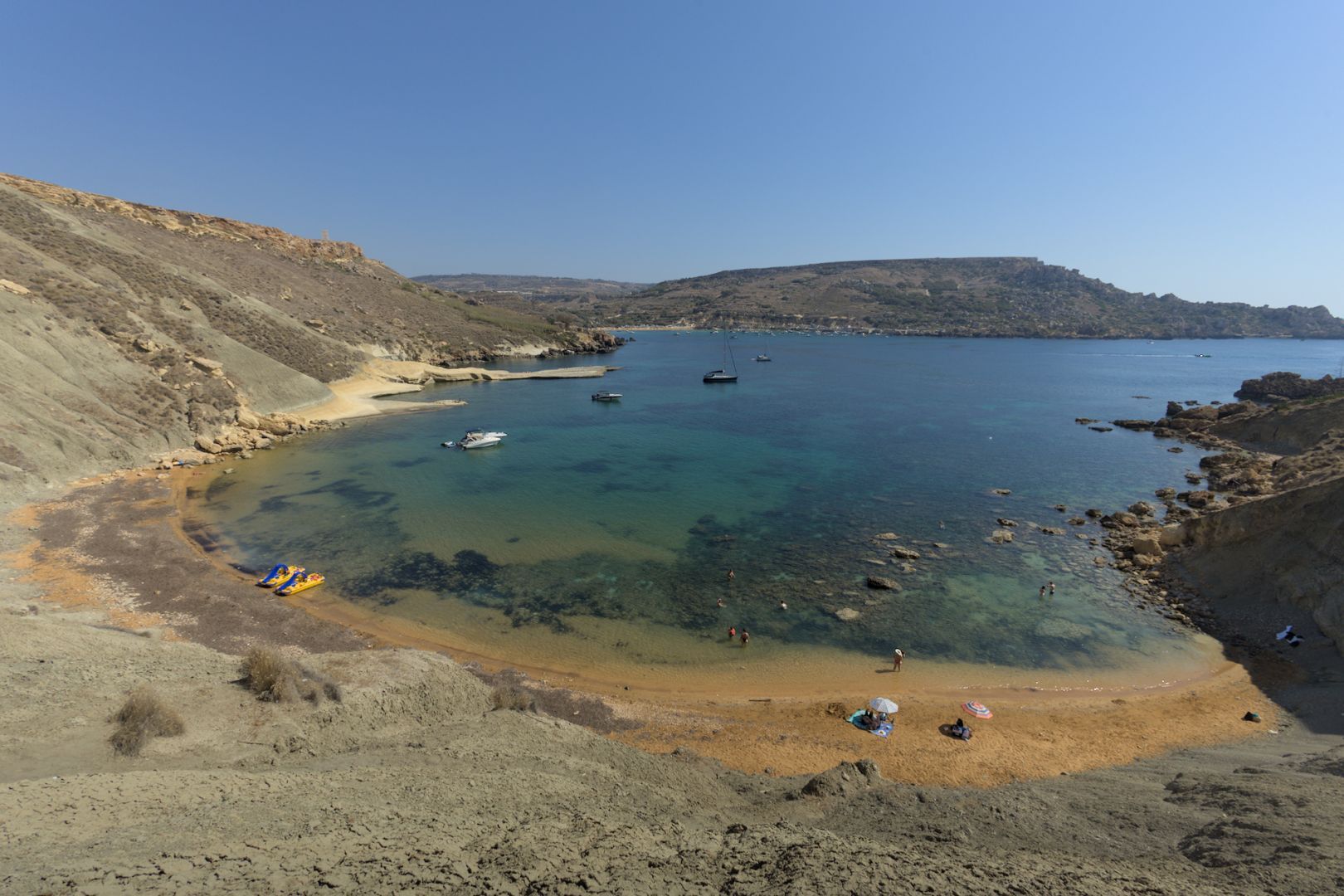 Fotografia d'una platja mediterrània idílica, amb molt poca gent.