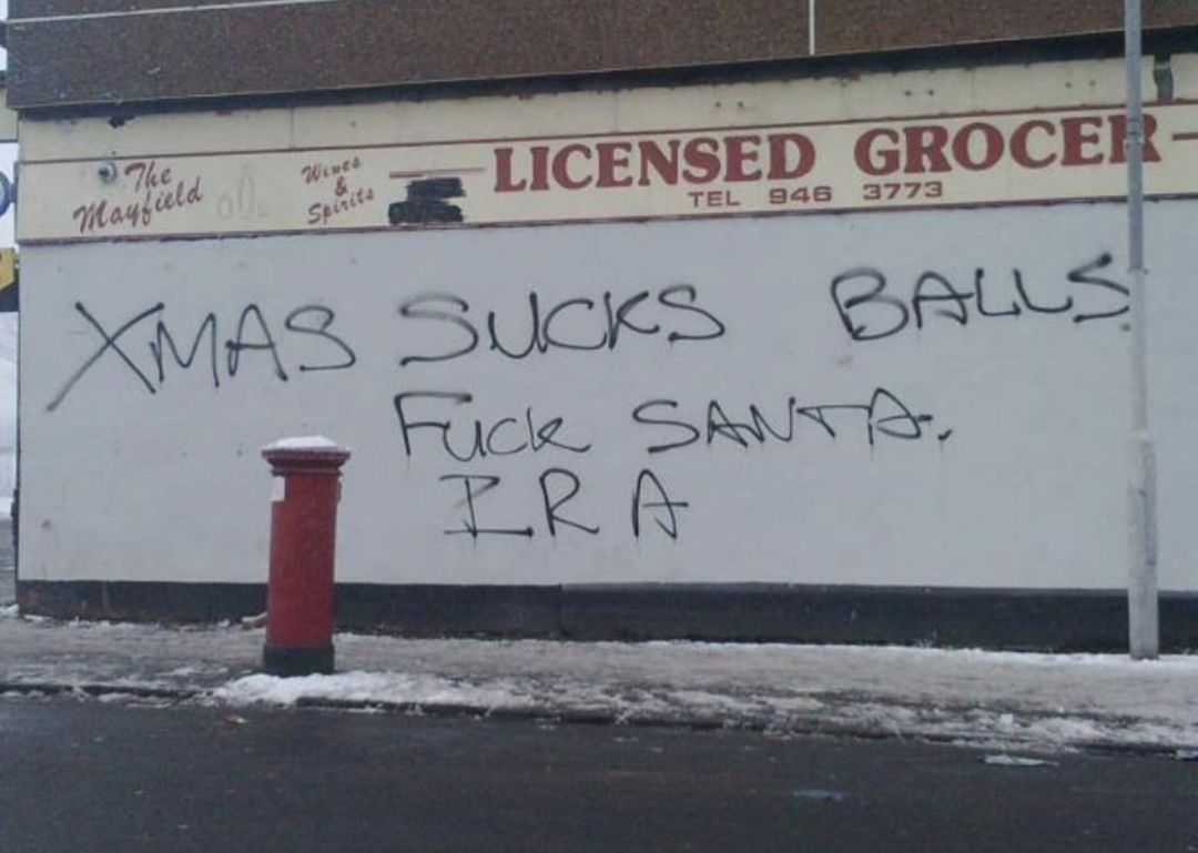 "Xmas sucks balls, fuck Santa, IRA" written on a wall with black spray paint