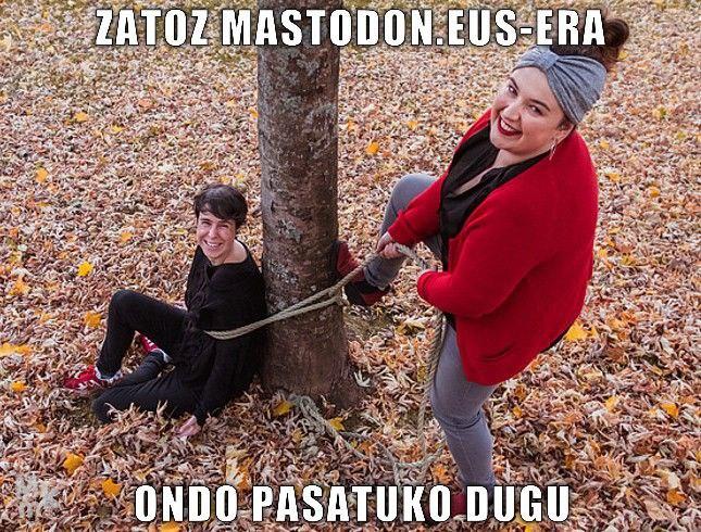 Zatoz Mastodon.eus-era, ondo pasatuko dugu irakurtzen da, emakume batek beste bat zuhaitz batera lotzen duen bitartean, biak irribarrez.